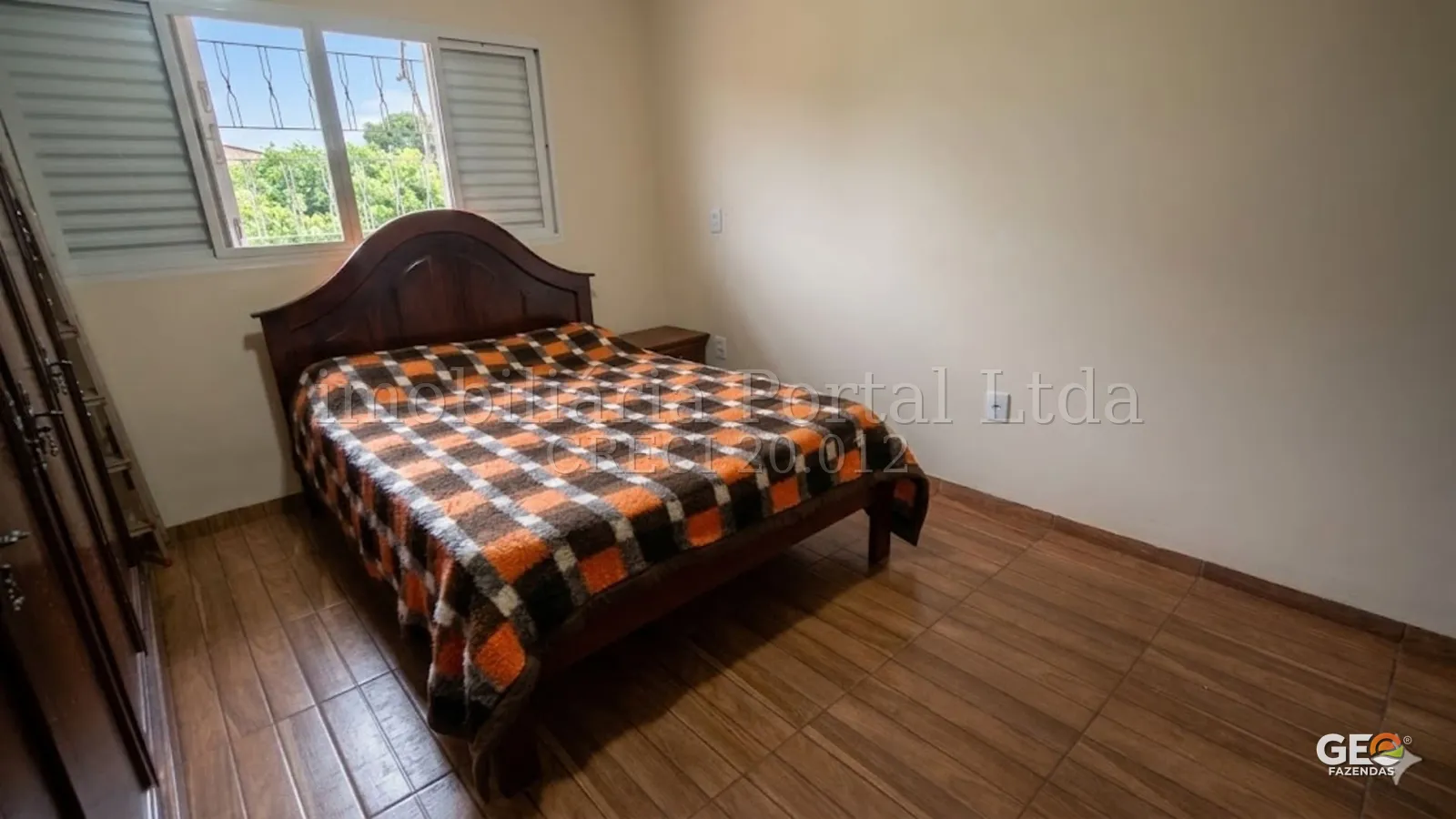 Quarto simples em propriedade rural com cama de madeira