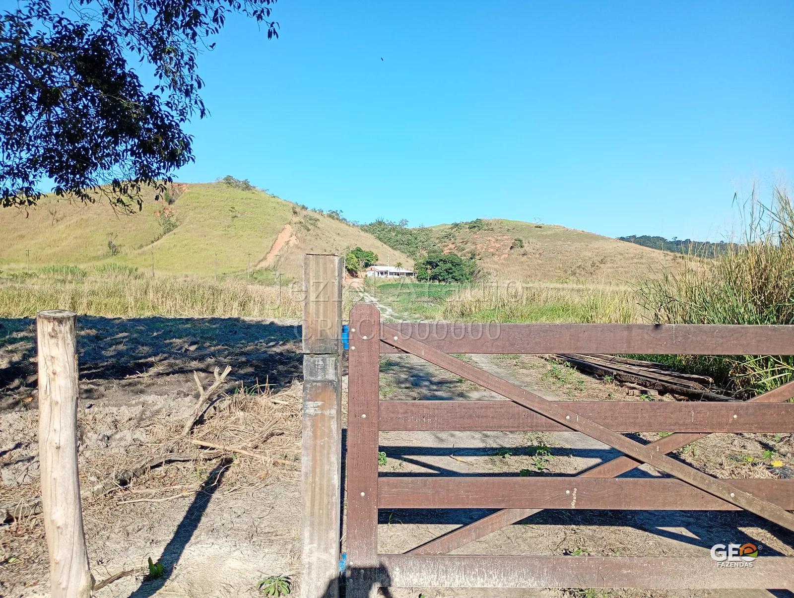 Entrada de fazenda com colinas ao fundo