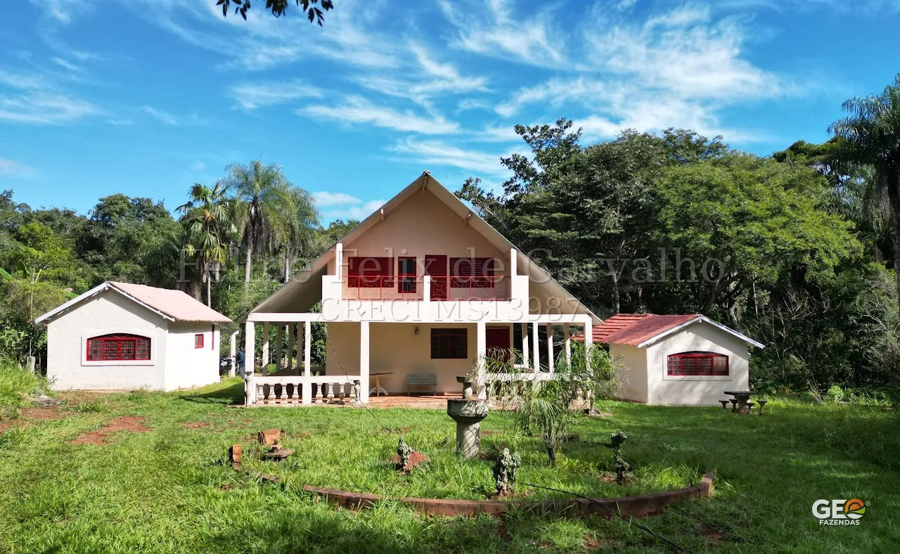 Casa rural com área verde e árvores ao redor