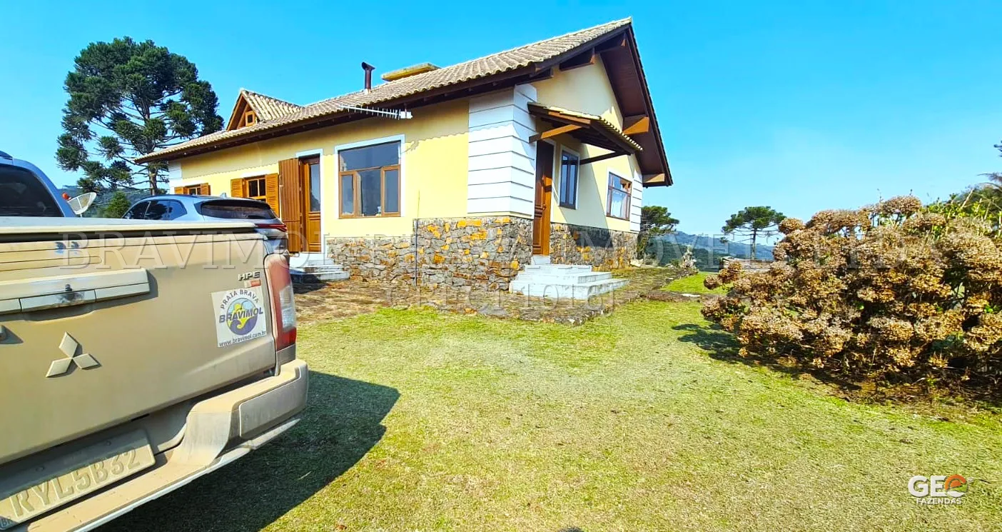 Casa rural com área externa e veículos