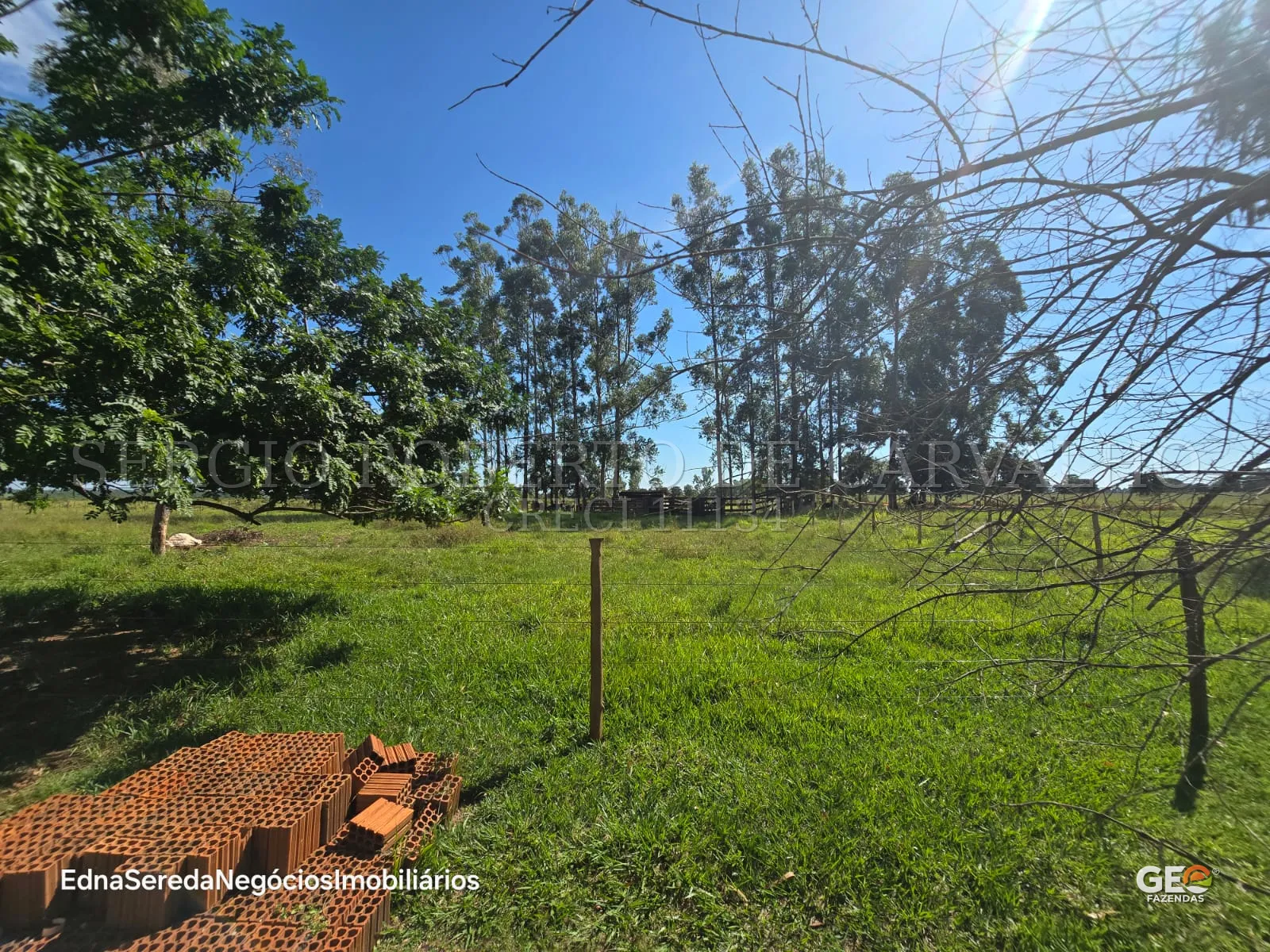 Área rural com vegetação e materiais de construção