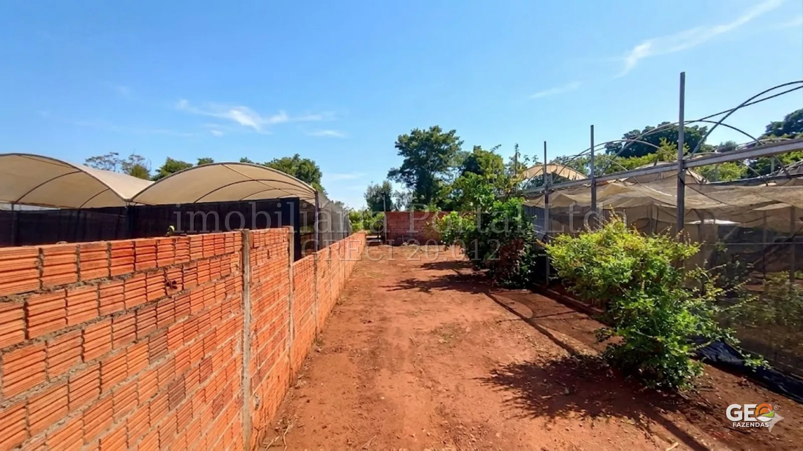 Área rural com estufas e terreno aberto
