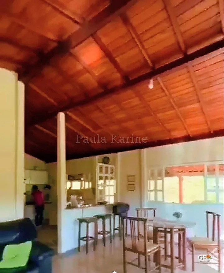 Interior de casa com teto de madeira e área de convivência