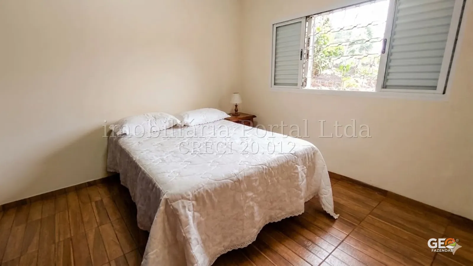 Quarto simples em imóvel rural com janela