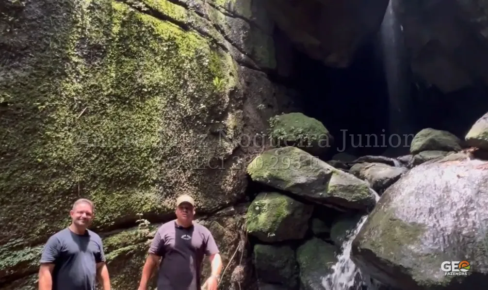 Homens próximos a cachoeira em área natural