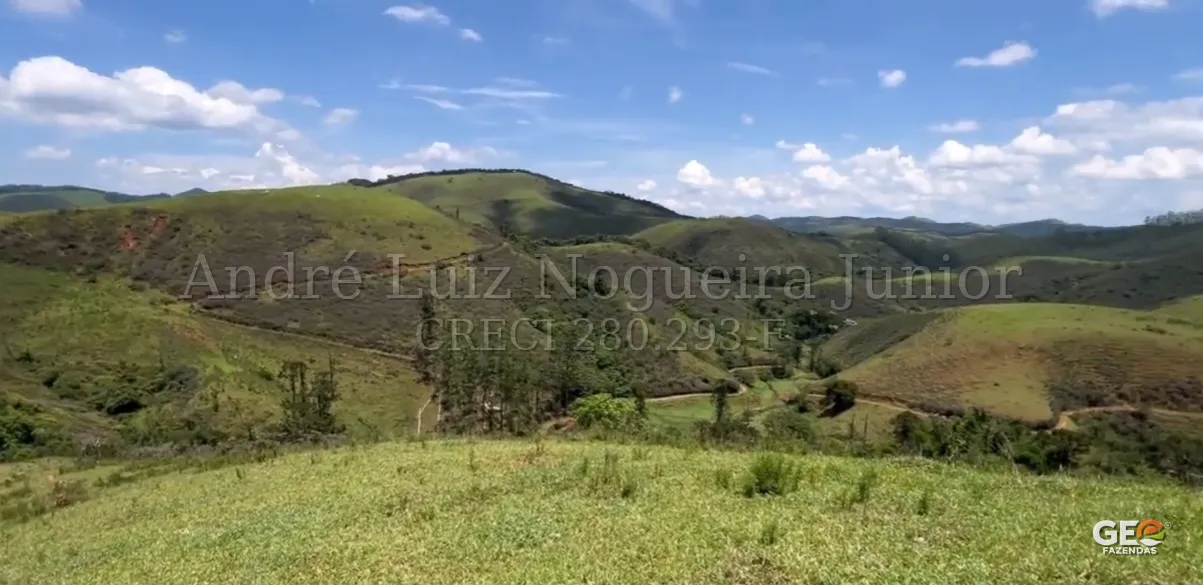 Terreno rural com colinas verdes e céu azul
