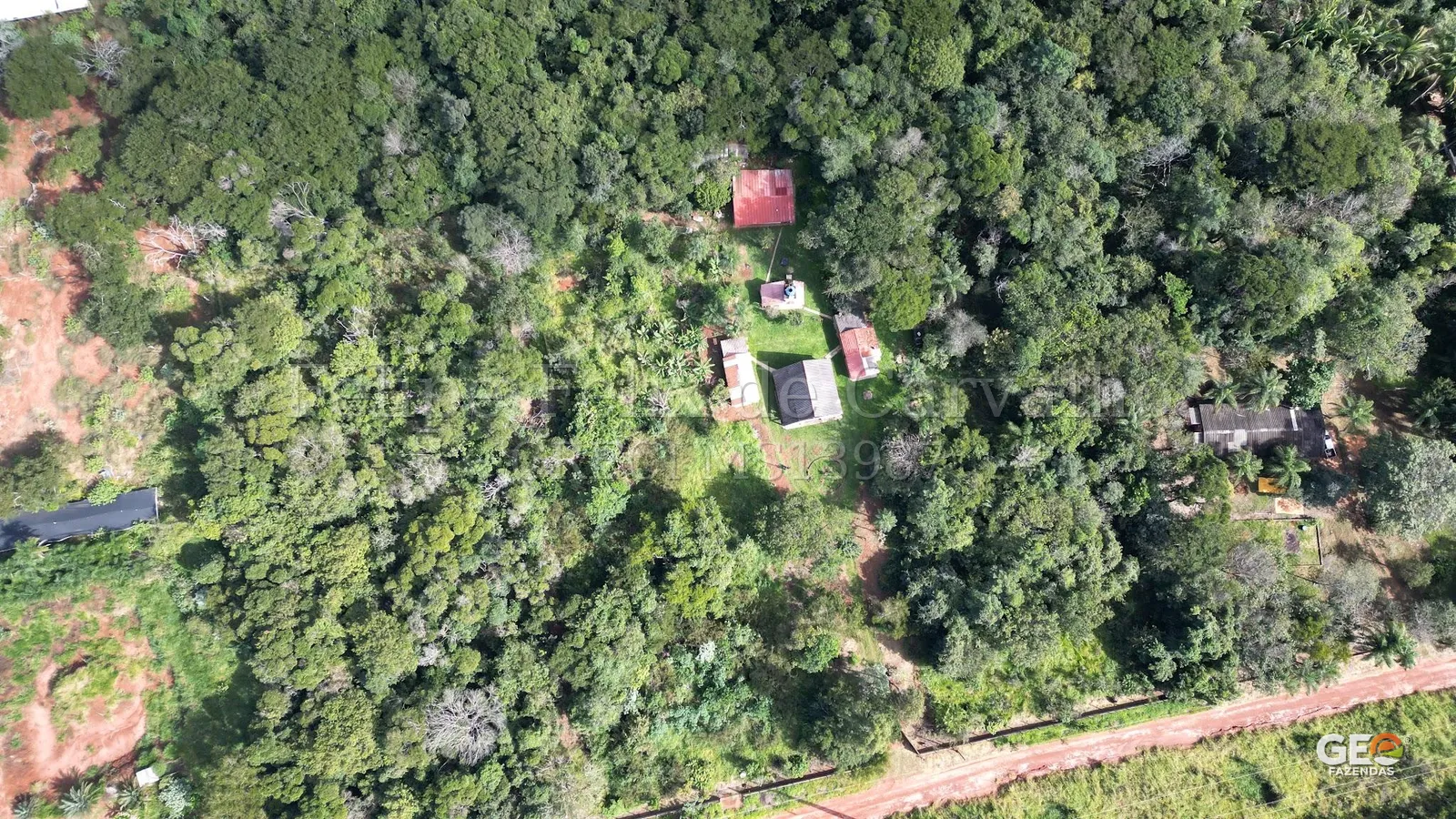 Vista aérea de propriedade rural com casas e mata