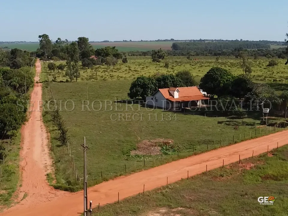 Casa rural com estrada de terra e pastagem