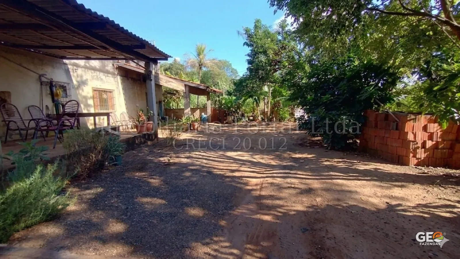 Área externa de propriedade rural com varanda e vegetação