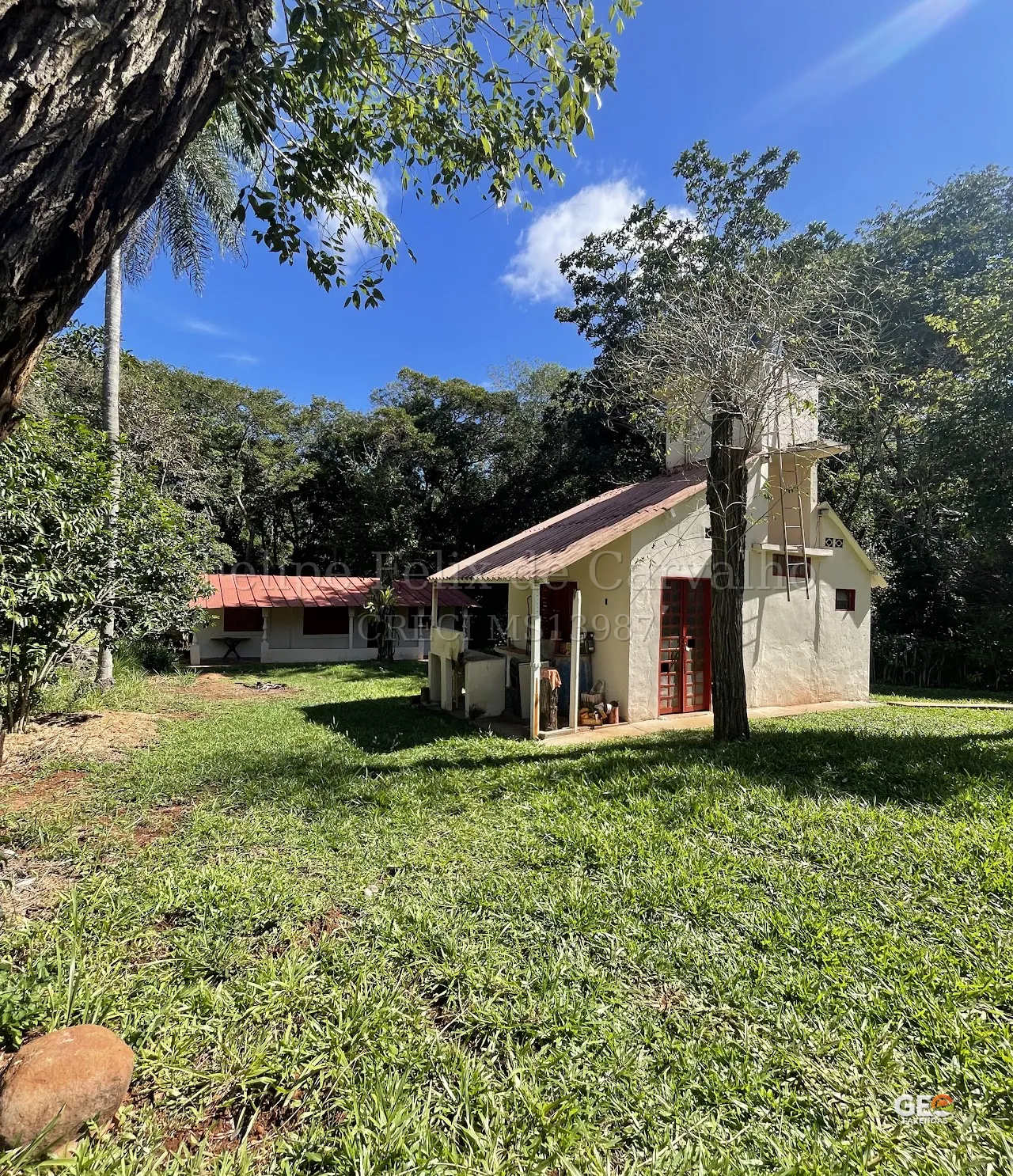 Casa rural com área verde e árvores ao redor