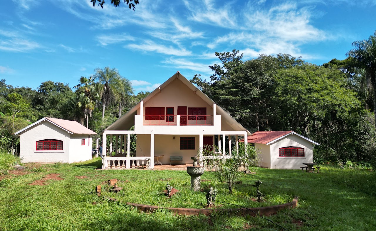 Casa rural com área verde e árvores ao redor
