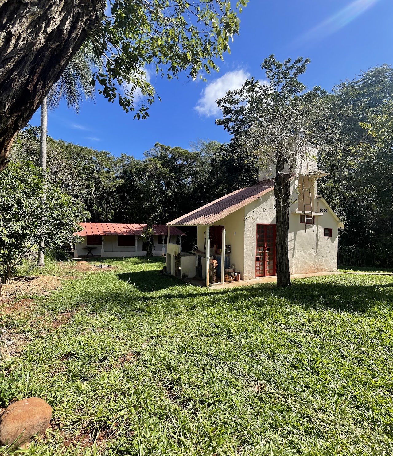 Casa rural com área verde e árvores ao redor